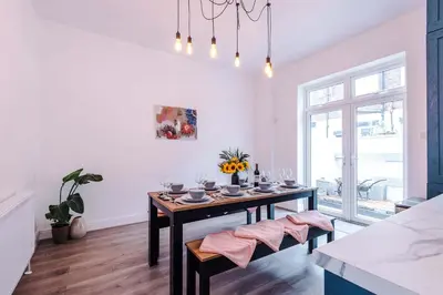 a dining room with a table and a window at Stunning & Spacious Home by 53 Degrees Property, Sleeps 7 in the heart of Anfield! in Liverpool