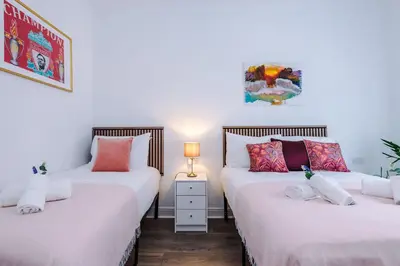 two beds in a room with white walls at Stunning & Spacious Home by 53 Degrees Property, Sleeps 7 in the heart of Anfield! in Liverpool