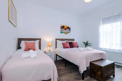 a bedroom with two beds with white and pink sheets at Stunning & Spacious Home by 53 Degrees Property, Sleeps 7 in the heart of Anfield! in Liverpool