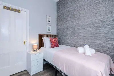 a bedroom with two beds and a brick wall at Stunning & Spacious Home by 53 Degrees Property, Sleeps 7 in the heart of Anfield! in Liverpool