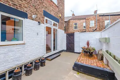 a patio with a table and a building at Stunning & Spacious Home by 53 Degrees Property, Sleeps 7 in the heart of Anfield! in Liverpool