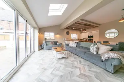 a living room with a couch and a table at Villa Rose-Spacious Home with beautiful garden in Lytham St Annes