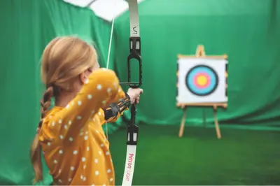 a girl holding a bow and arrow in front of a target at Haven SAN 107 in Blackpool