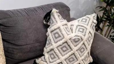 a pillow is sitting on a couch with at Stylish Liverpool Apartment with Parking & Balcony in Liverpool