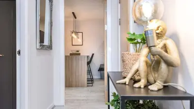 a statue of a woman sitting on a table reading a book at Stylish Liverpool Apartment with Parking & Balcony in Liverpool