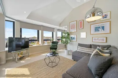 a living room with a couch and a flat screen tv at Waterfront Penthouse with Balcony & Parking in Liverpool