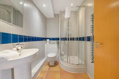 a bathroom with a sink and a shower and a toilet at Waterfront Penthouse with Balcony & Parking in Liverpool