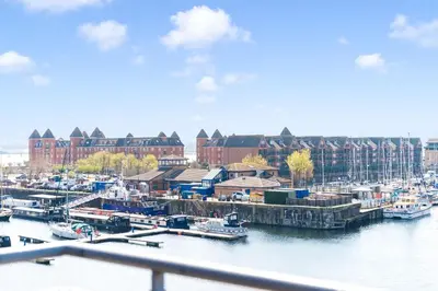 a marina with boats in the water and buildings at Waterfront Penthouse with Balcony & Parking in Liverpool