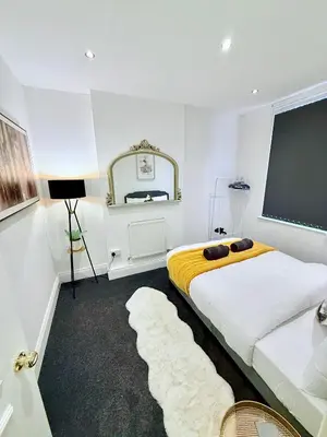a bedroom with a large bed and a large window at Vance Holiday Home in Blackpool