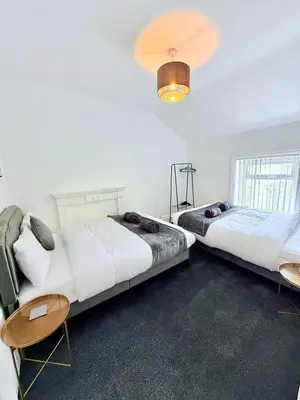 a bedroom with two beds and a table and chairs at Vance Holiday Home in Blackpool