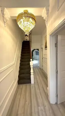 a chandelier hangs over a staircase in a house at Vance Holiday Home in Blackpool