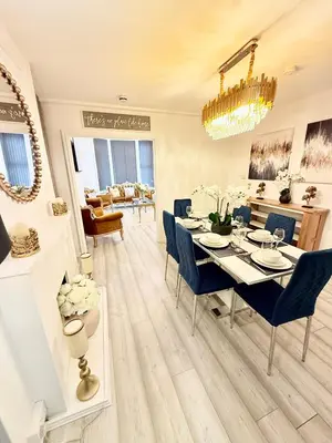 a dining room with a table and blue chairs at Vance Holiday Home in Blackpool