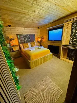 a bedroom with a bed and a large window at Woodland Escapes Glamping - Utopia