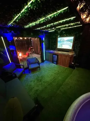 a room with a stage with a screen and chairs at Woodland Escapes Glamping - Utopia