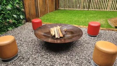 a wooden table and two stools in a yard at Woodland Escapes Glamping - Utopia