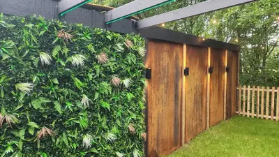 a privacy hedge with a wooden gate in a yard at Woodland Escapes Glamping - Utopia