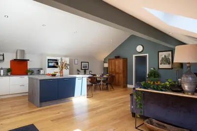 a large kitchen and living room with a table at Curlew Loft in Lancaster