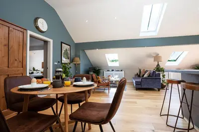 a dining room and living room with a table and chairs at Curlew Loft in Lancaster