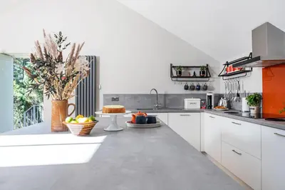 a kitchen with white cabinets and a counter with fruit on it at Curlew Loft in Lancaster