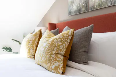 a pile of pillows sitting on top of a bed at Curlew Loft in Lancaster