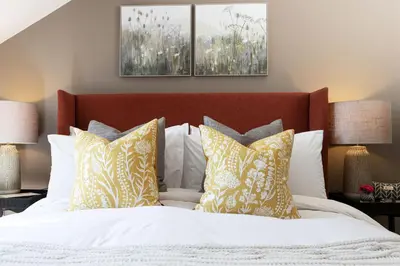 a bedroom with a bed with white and yellow pillows at Curlew Loft in Lancaster