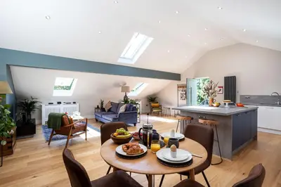 a kitchen and living room with a table and chairs at Curlew Loft in Lancaster