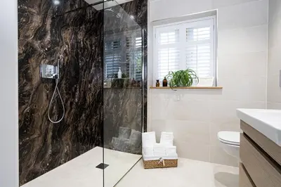 a bathroom with a shower with a glass door at Hen Harrier Lodge in Lancaster