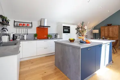 a kitchen with white cabinets and a blue island at Bowland Lodges in Lancaster