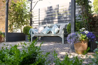 a bench with pillows on it in a garden at Bowland Lodges in Lancaster