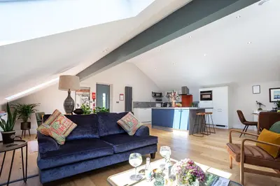 a living room with a blue couch and a kitchen at Bowland Lodges in Lancaster