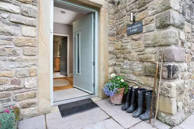 a door to a stone building with boots next to it at Bowland Lodges in Lancaster