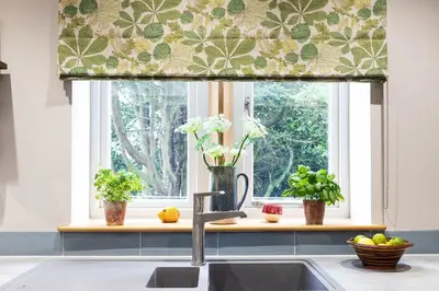 a kitchen with a sink and a window with a curtain at Bowland Lodges in Lancaster