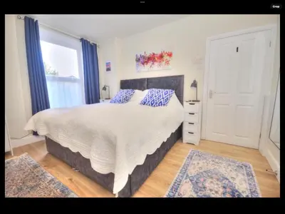 a bedroom with a large bed with blue pillows at The Hollies in Crosby