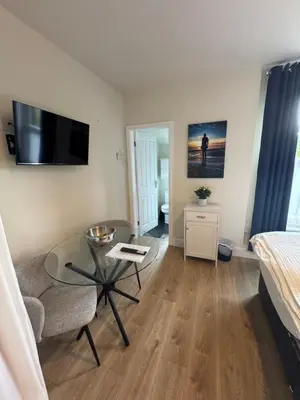 a living room with a table and a bed at The Hollies in Crosby