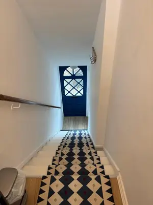 a hallway with a blue door and a tile floor at The Hollies in Crosby