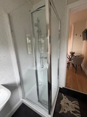 a glass shower in a bathroom with a sink at The Hollies in Crosby
