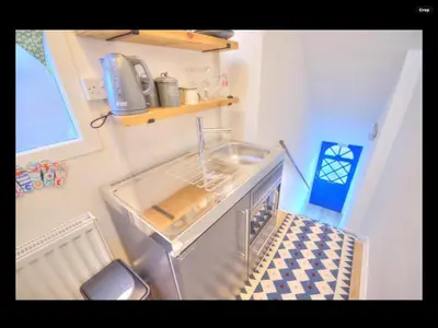 a small kitchen with a sink in a room at The Hollies in Crosby