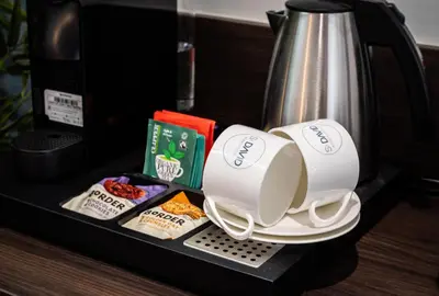 a coffee maker with two cups and some food at The Old Brewery - A St David Aparthotel in Barrow in Furness