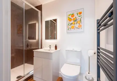 a white bathroom with a toilet and a shower at The Old Brewery - A St David Aparthotel in Barrow in Furness