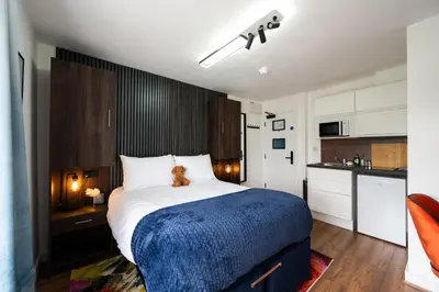 a bedroom with a bed with a teddy bear on it at The Old Brewery - A St David Aparthotel in Barrow in Furness