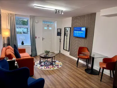 a living room with a couch and a table and chairs at The Old Brewery - A St David Aparthotel in Barrow in Furness