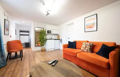 a living room with an orange couch and a table at The Old Brewery - A St David Aparthotel in Barrow in Furness