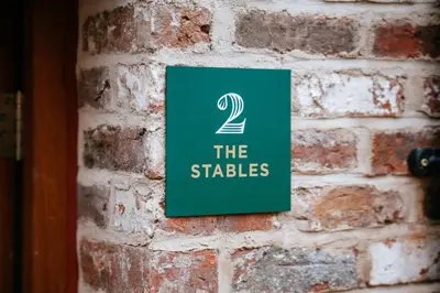a green sign on a brick wall with the stables at The Stables at The Talbot in Lytham St Annes