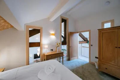 a bedroom with a bed and a desk and windows at The Stables at The Talbot in Lytham St Annes