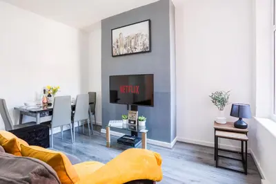 a living room with a couch and a dining room at Leisure Stays with Wifi Close to Anfield, sleeps 8 in Liverpool
