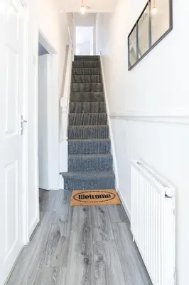 a staircase with a welcome mat on the floor at Leisure Stays with Wifi Close to Anfield, sleeps 8 in Liverpool