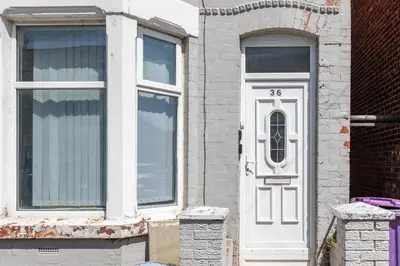 a house with a white door and a window at Leisure Stays with Wifi Close to Anfield, sleeps 8 in Liverpool