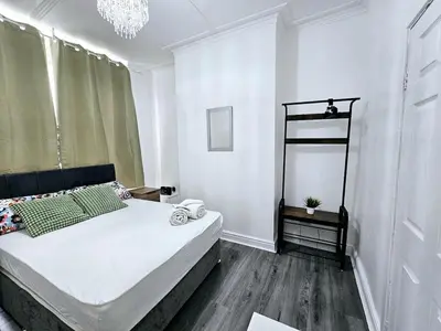 a bedroom with a large white bed and a chandelier at Comfort in Liverpool