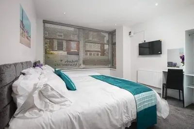 a bedroom with a large white bed with a window at Polaris Apartments in Blackpool