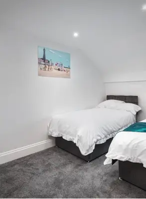a bedroom with two beds and a picture on the wall at Polaris Apartments in Blackpool